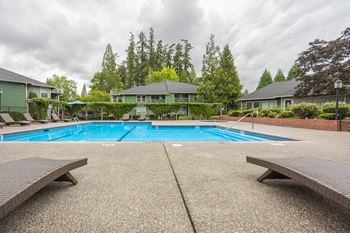 A pool surrounded by benches and trees.